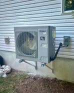 Un grand climatiseur est monté sur le côté d'une maison.