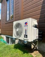 Un climatiseur blanc est monté sur le côté d'une maison.
