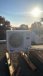 Un climatiseur blanc est posé sur un toit.