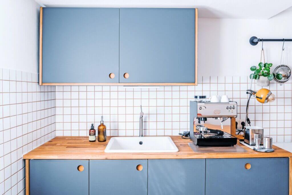 Blue wooden coastal kitchen cabinets with white tile backsplash