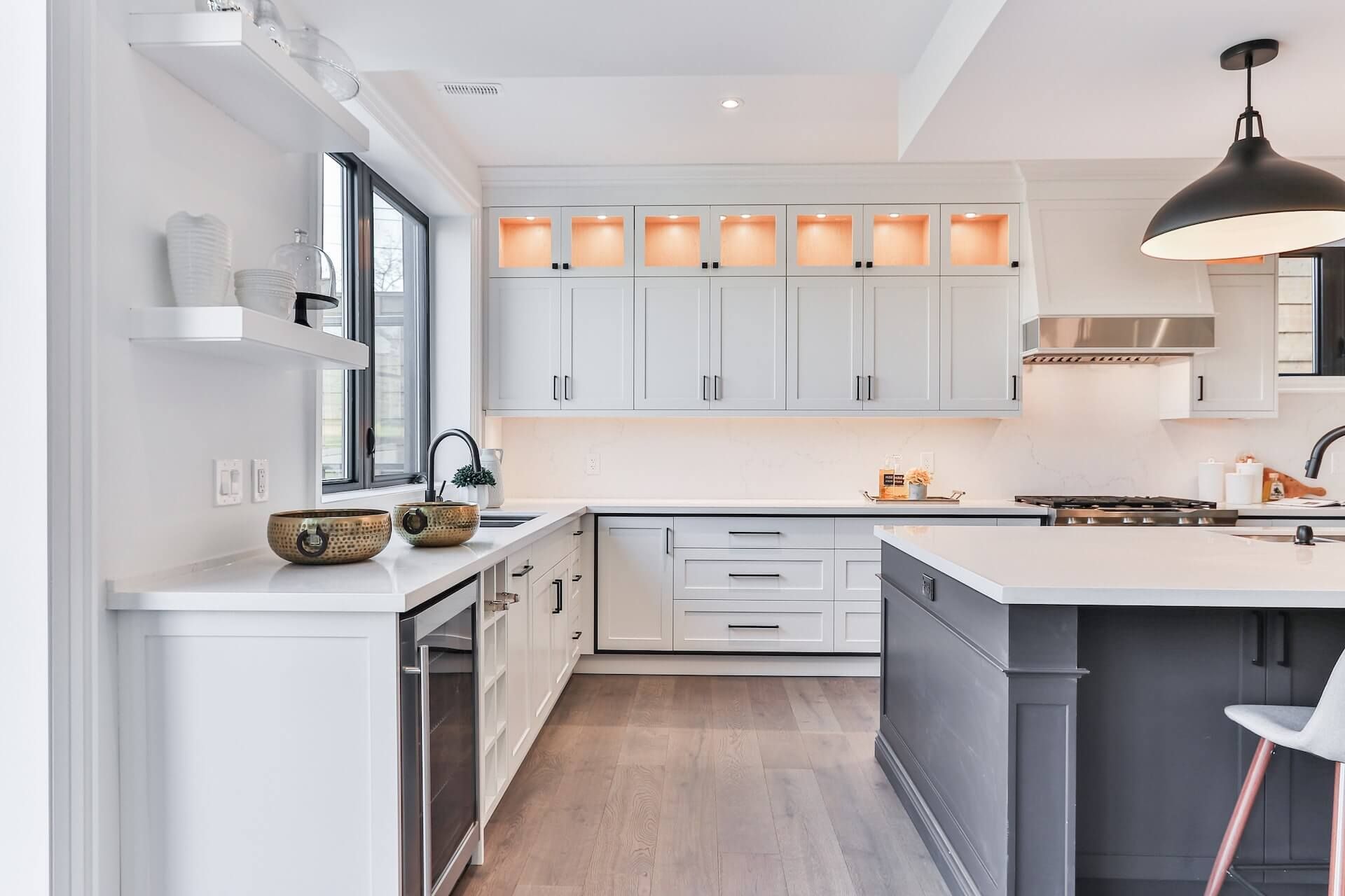 White kitchen layout with island in center and two different sinks