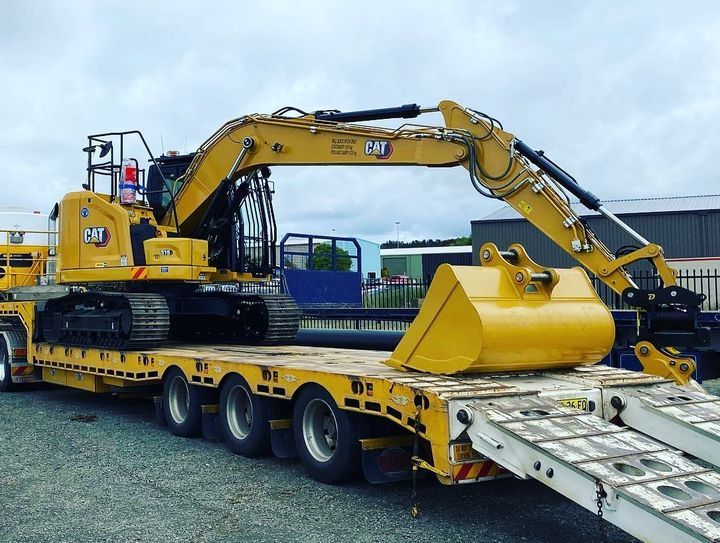 A Yellow Excavator Is Sitting On Top Of A Yellow Trailer — Blackpoly Pipelines in Mudgee, NSW