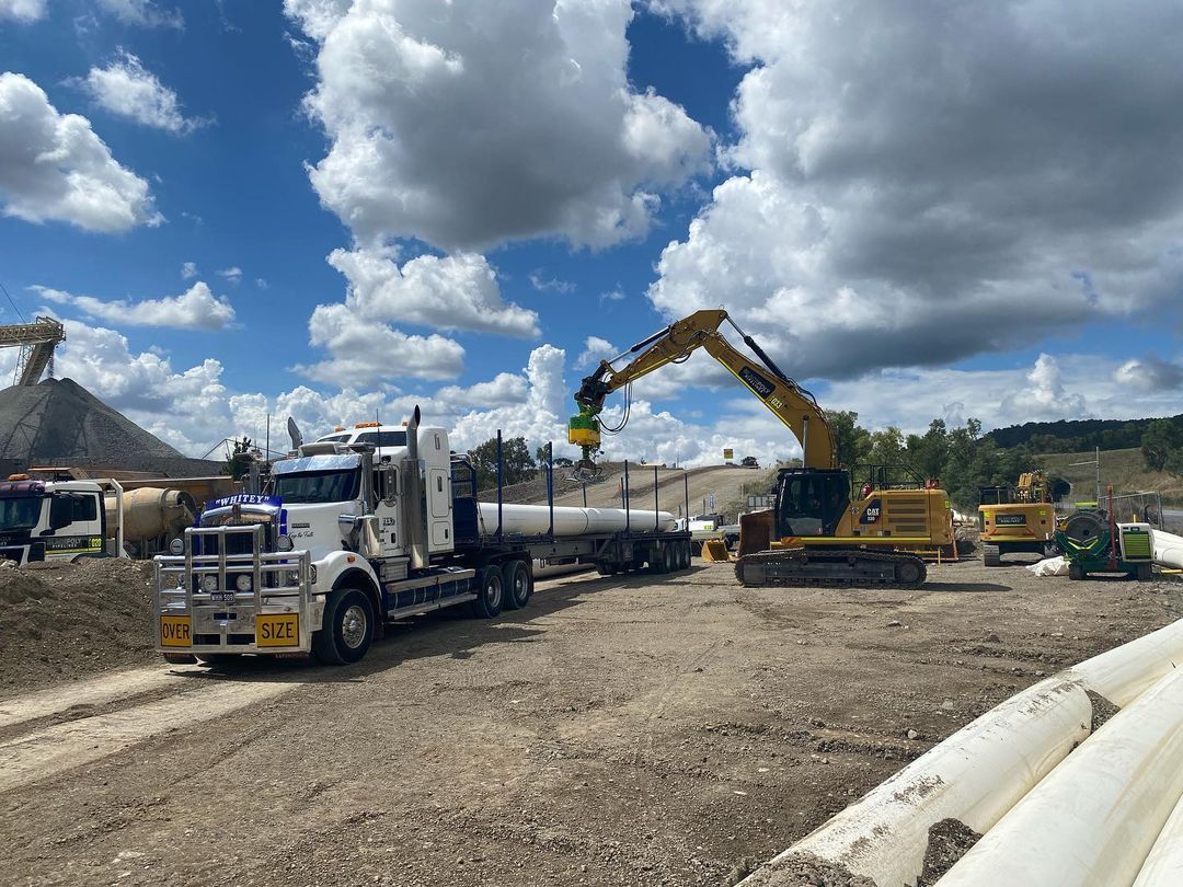 A Truck Is Being Loaded With Pipes In A Construction Site — Blackpoly Pipelines in Orange, NSW