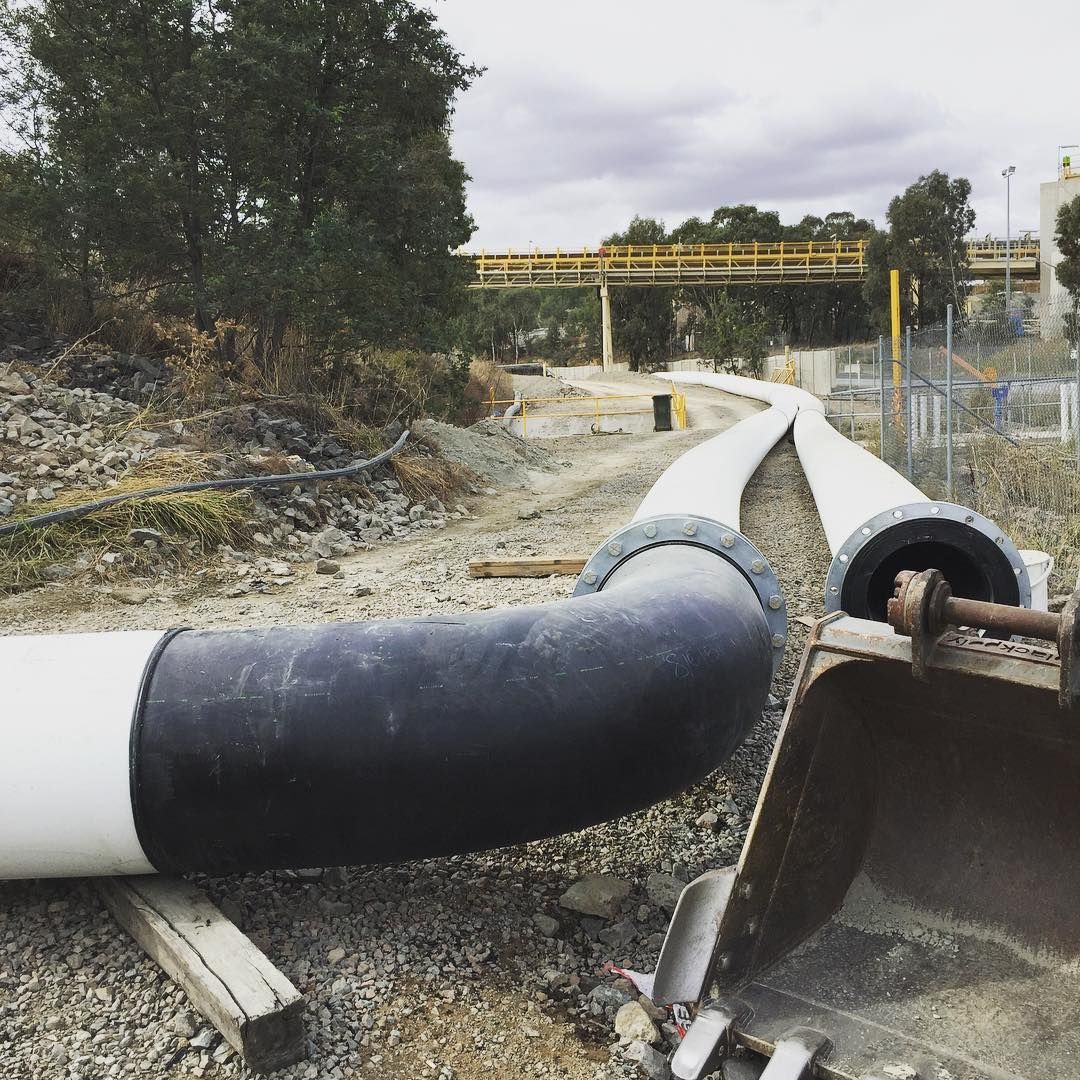 A Construction Site With Pipes And A Bridge In The Background — Blackpoly Pipelines in Orange, NSW