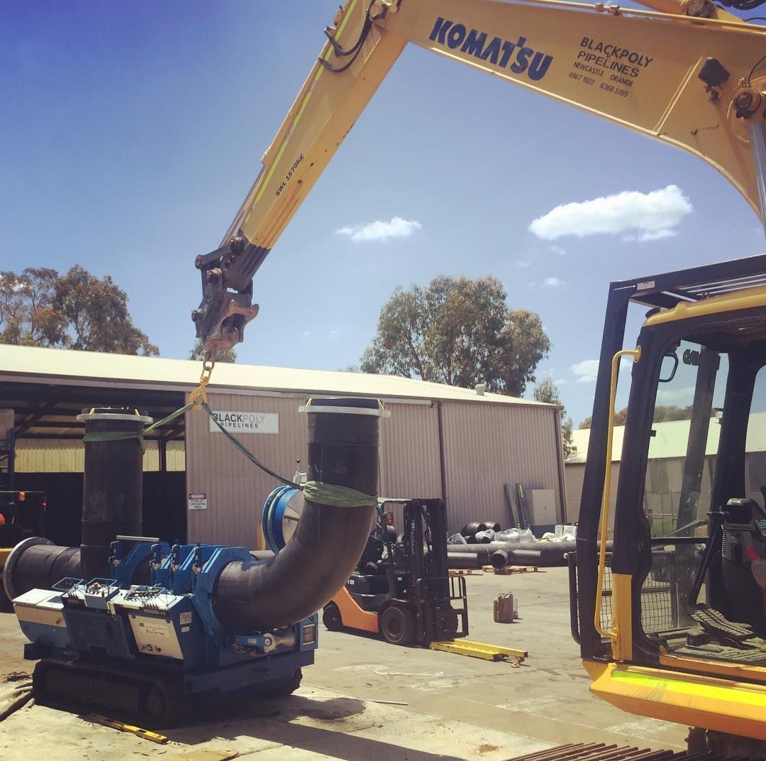 A Yellow Komatsu Excavator Is Working On A Pipe — Blackpoly Pipelines in Orange, NSW