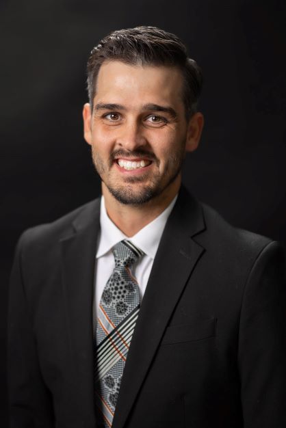 A man in a suit and tie is smiling for the camera.