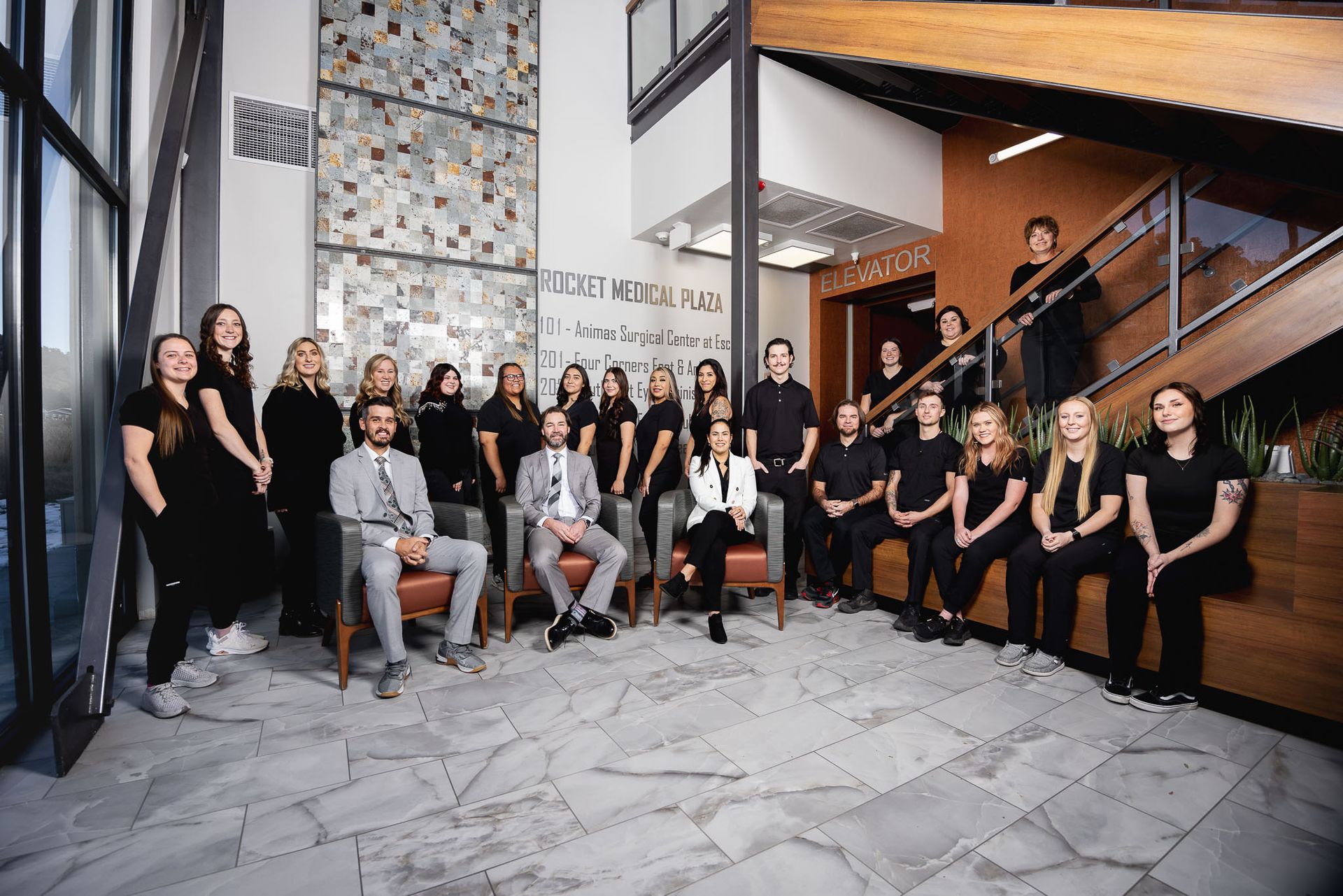 The Four Corners Foot and Ankle team are posing for a picture in a lobby.