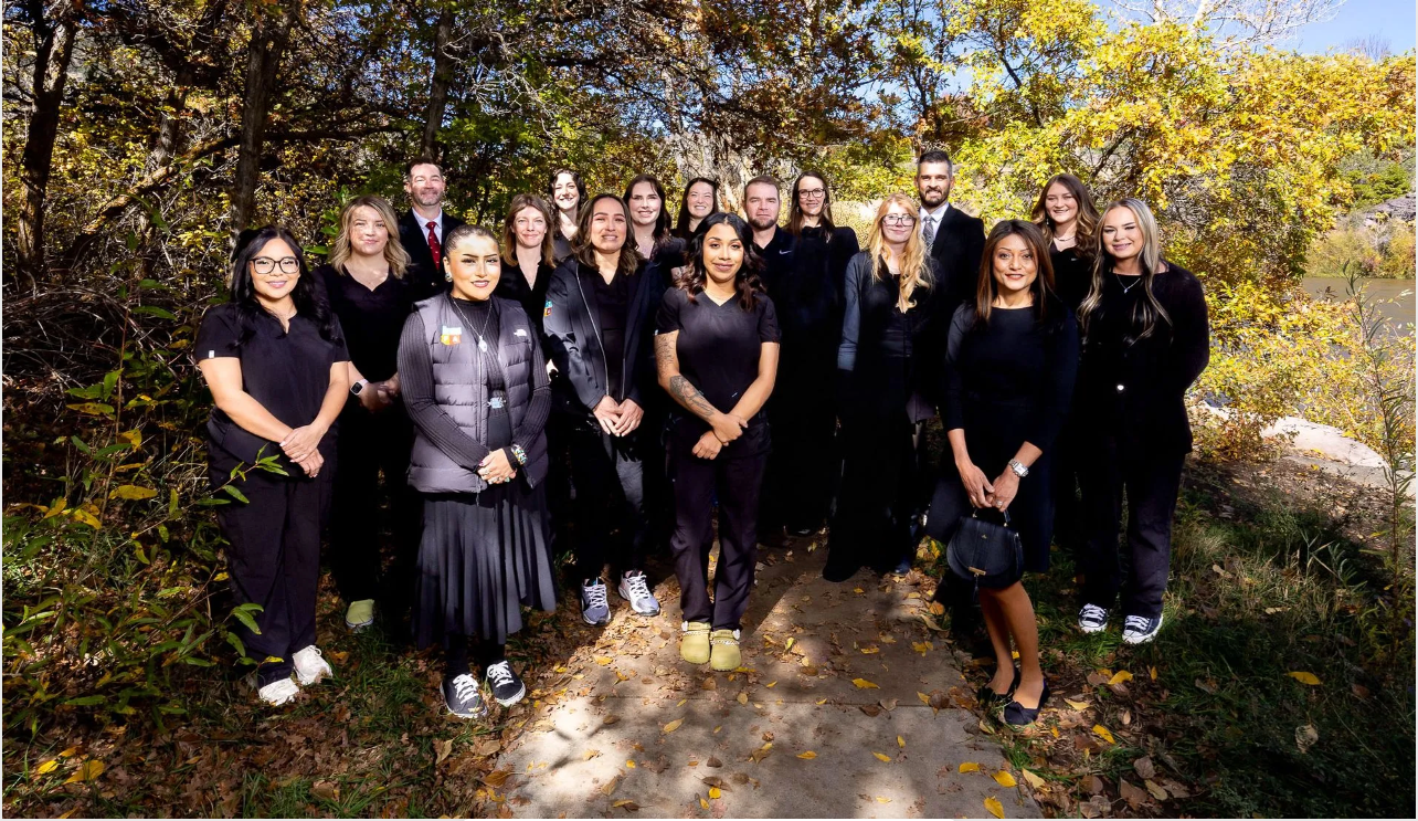 The Four Corners Foot and Ankle team are posing for a picture in a lobby.