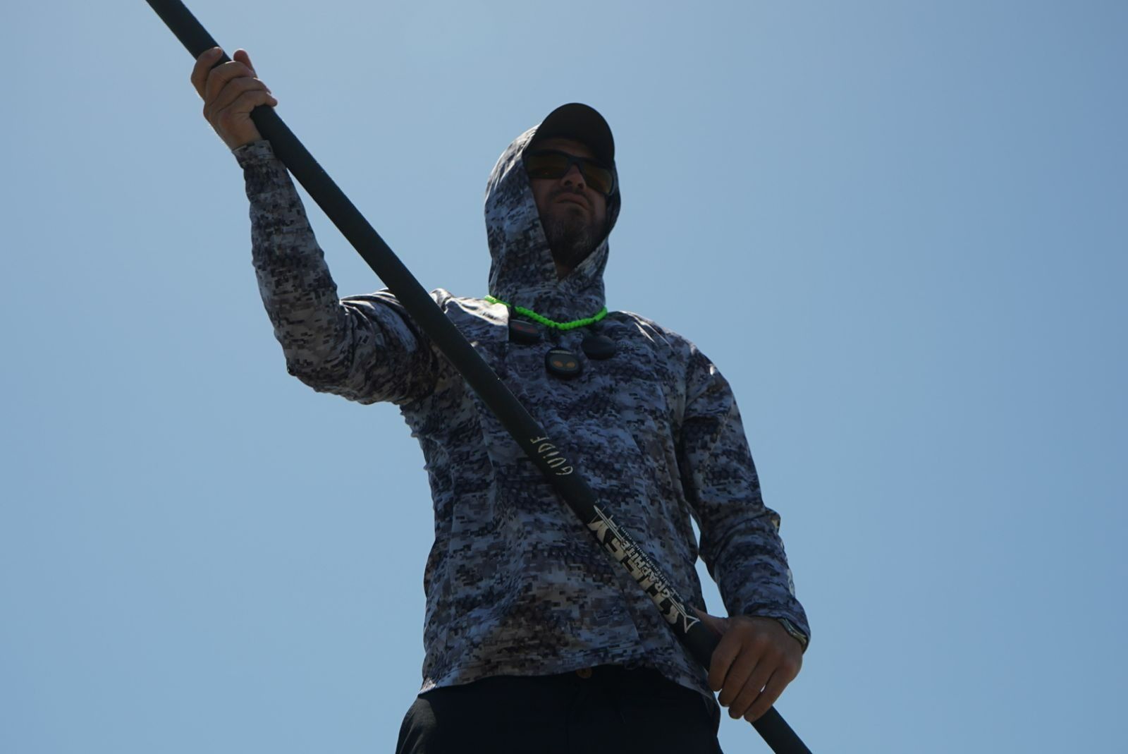 A man in a hoodie is holding a pole in his hand.