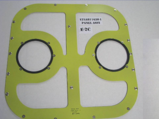 Yellow panel with two circular openings and black seals, held in place by numerous screws.