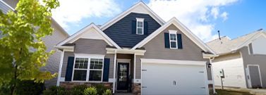 Exterior of a two-story house with gray siding, white trim, and a navy blue gable.