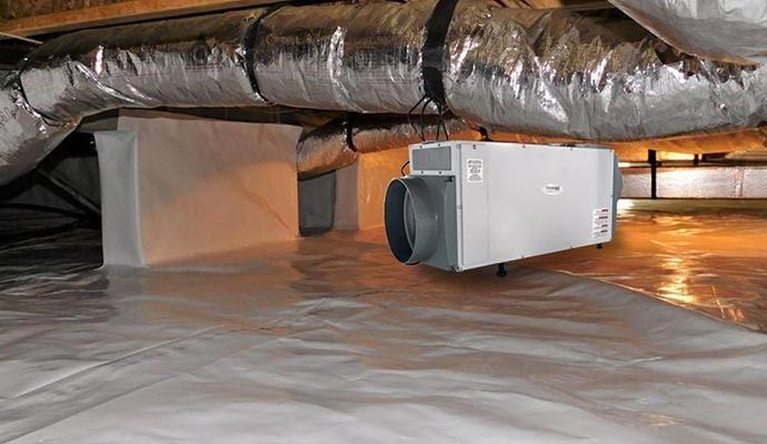 Crawlspace with white plastic ground cover, insulation, ductwork, and a dehumidifier.