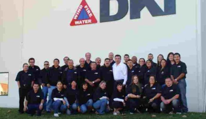 Group of people in black shirts posing in front of building with