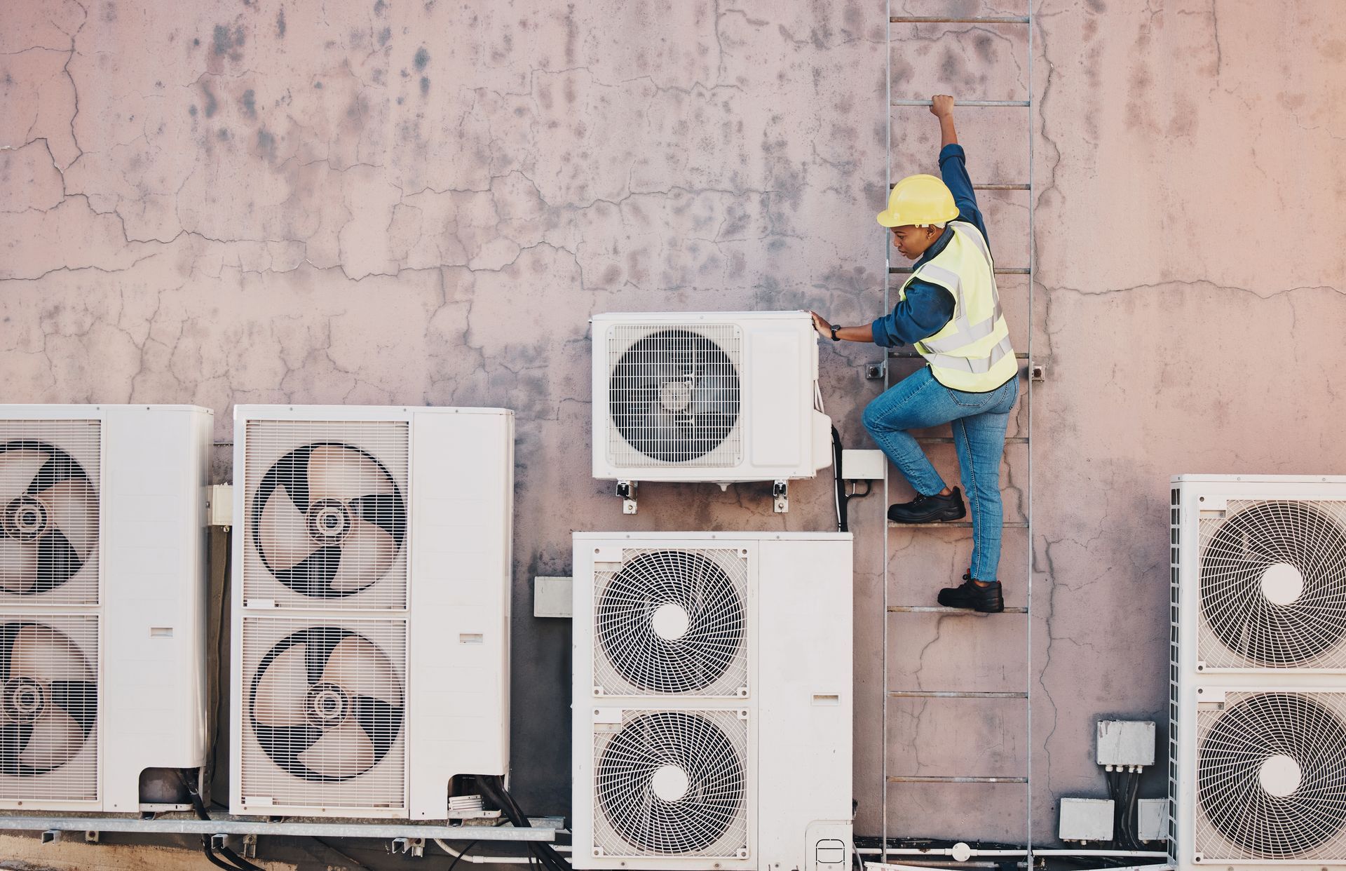 A HVAC repair man instaling and checking a heating and cooling system
