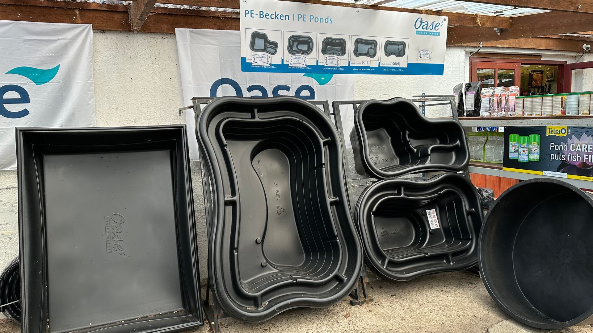 A bunch of plastic containers are sitting on top of each other in front of a sign.