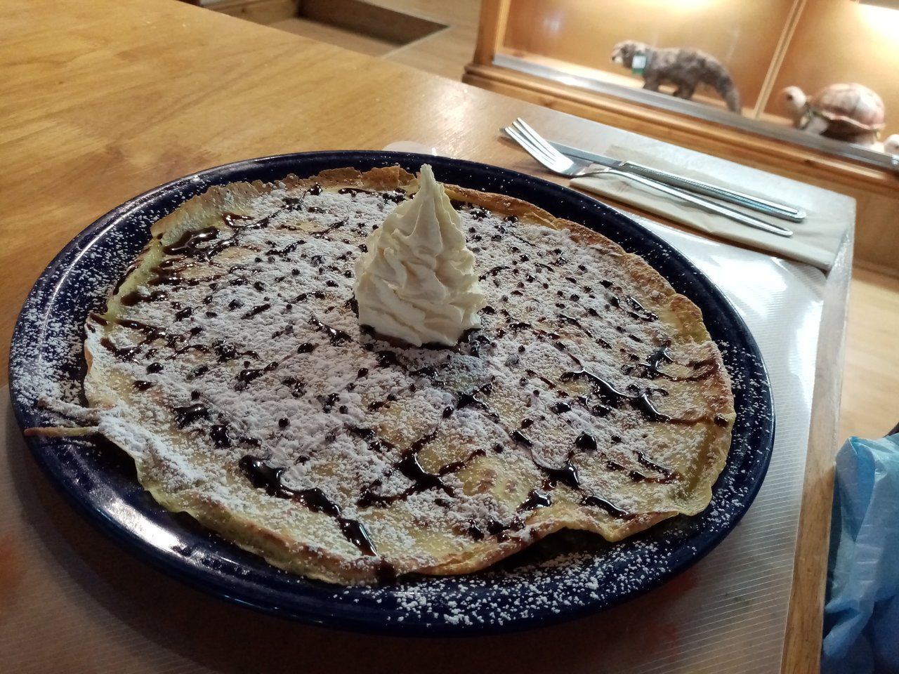 A pancake with powdered sugar and whipped cream on top