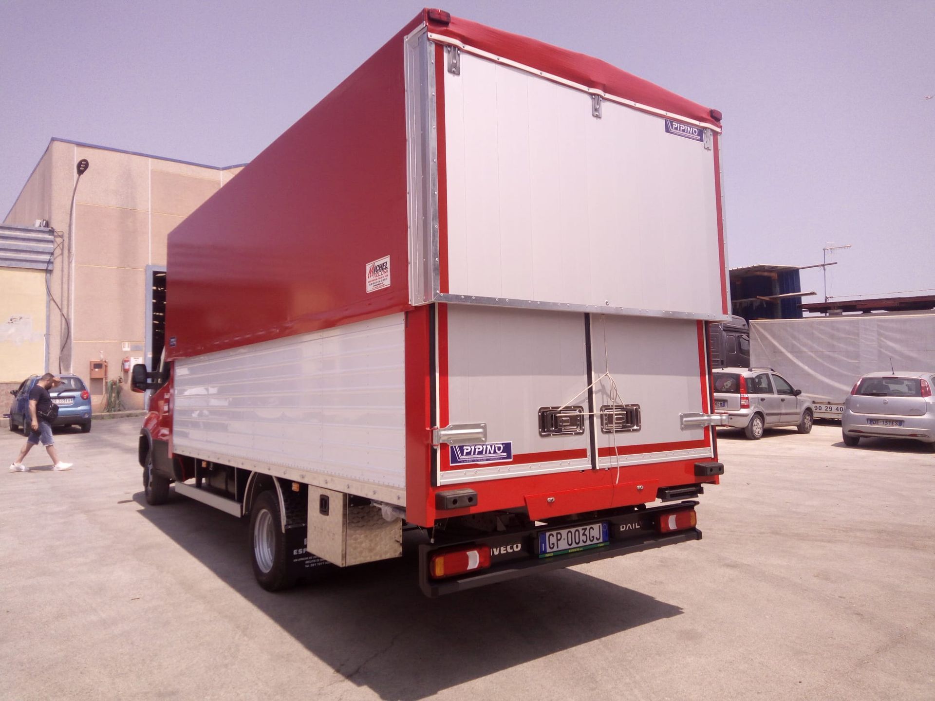 Un camion rosso e bianco è parcheggiato in un parcheggio