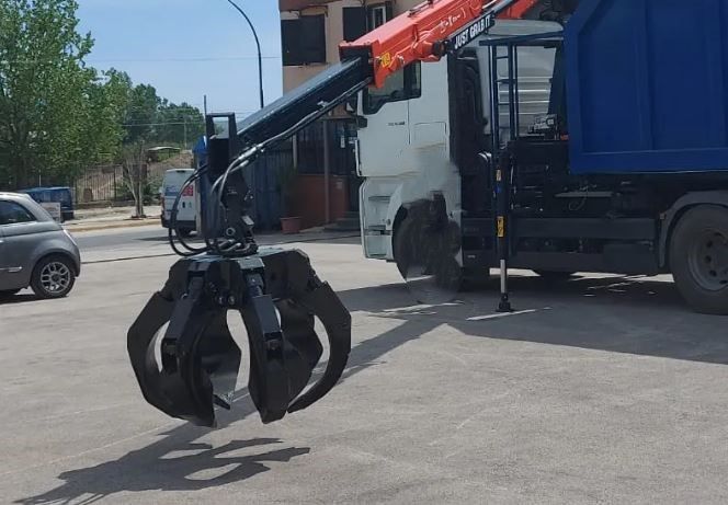 Un camion della spazzatura con una gru attaccata