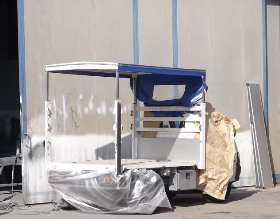 Un camion bianco con una tettoia blu è avvolto nella plastica