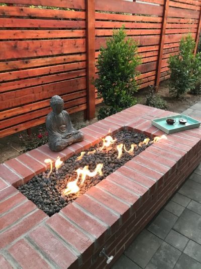 A fire pit made of bricks with a Buddha crafted by Turfworks, Inc., the best paver contractor in Vacaville, CA