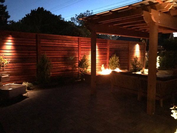 A pergola is lit up at night in a backyard | Outdoor Lighting in Davis, CA