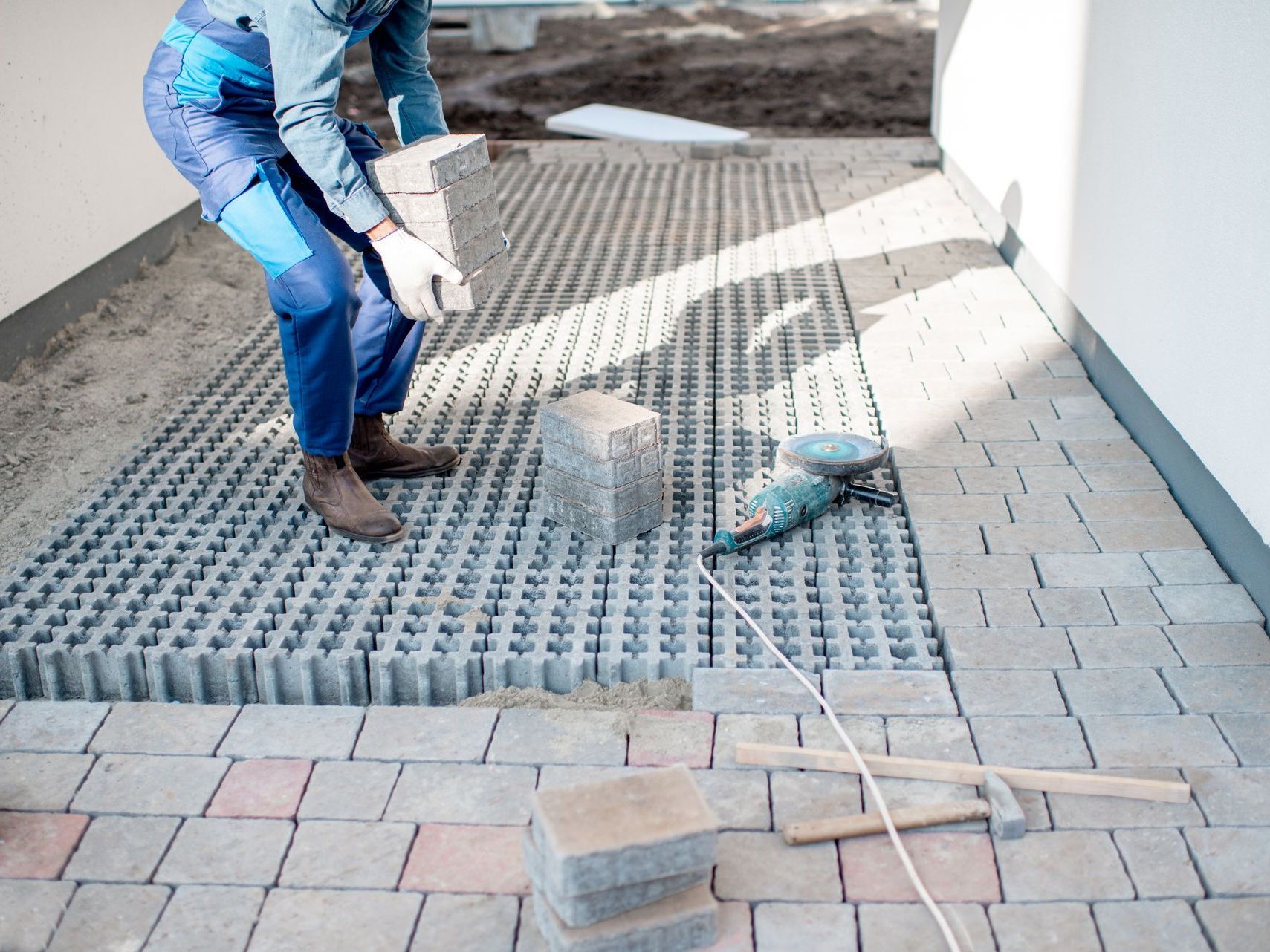 A man laying paving tiles on a patio crafted by the best paver contractor in Vacaville, CA - Turfworks Inc.