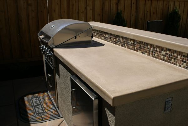 Outdoor kitchen with a stainless steel grill on a stone countertop built by Turfworks Inc. Vacaville’s top landscape contractor.