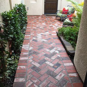Brick walkway in a zigzag pattern leading to a patio with greenery by Turfworks Inc. Top paver contractor in Vacaville, CA.