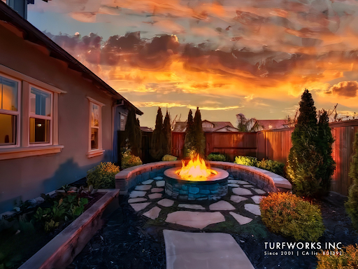 A fire pit in the backyard of a house with a sunset in the background.