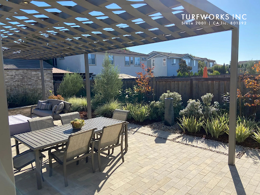 Patio with pergola, outdoor dining set, seating area, and landscaped garden.