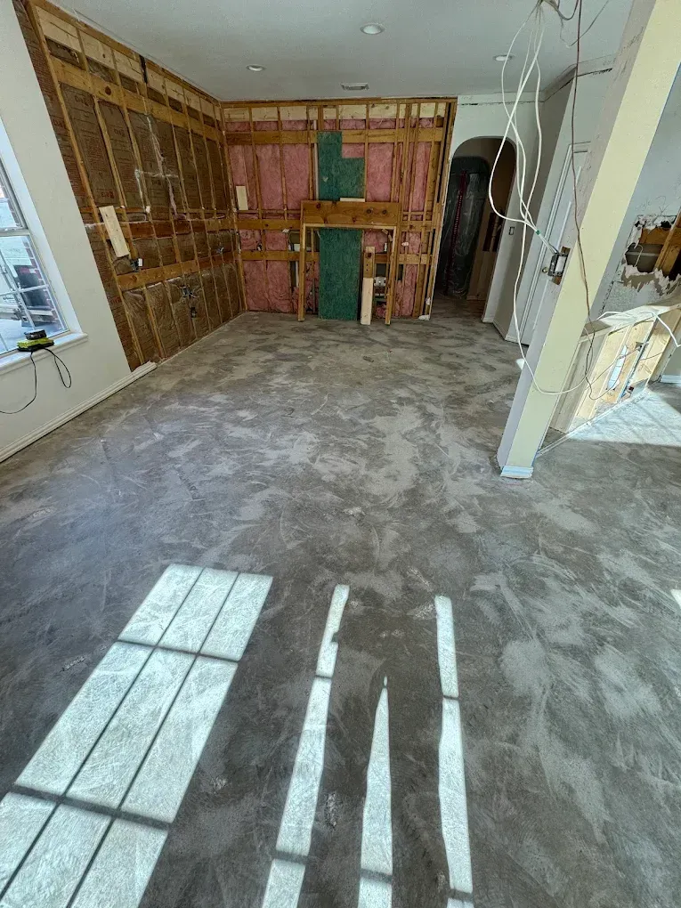 Room under construction with exposed framing, insulation, and concrete floor.