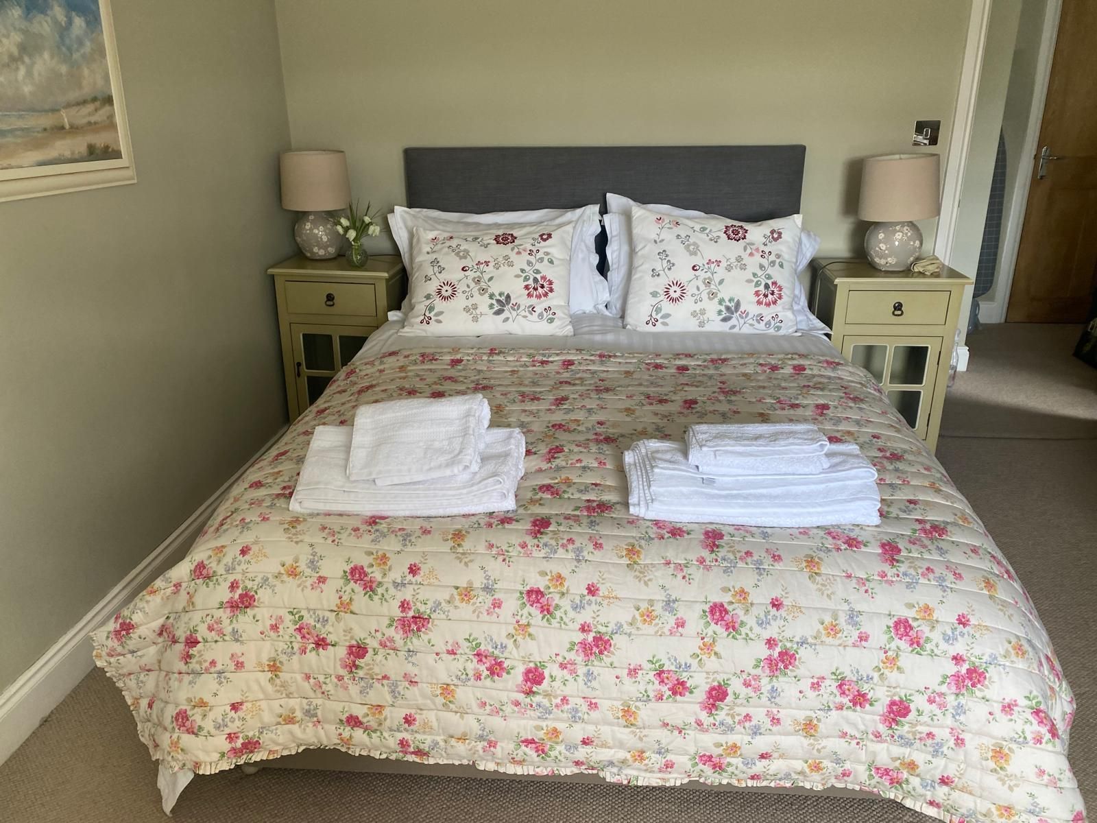 Bedroom white towels at Blades Cottage