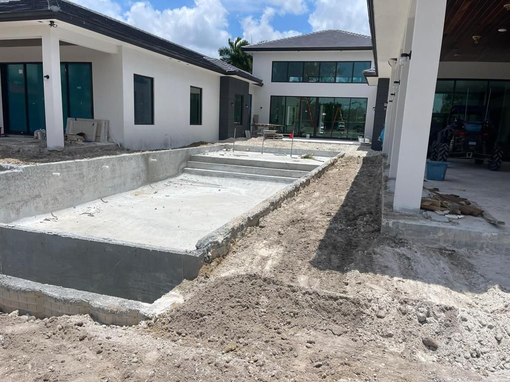 A large white house is being built with a swimming pool in the backyard.