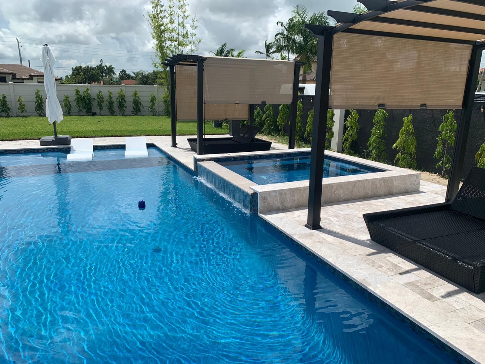 A large swimming pool with a gazebo and umbrellas in the backyard.
