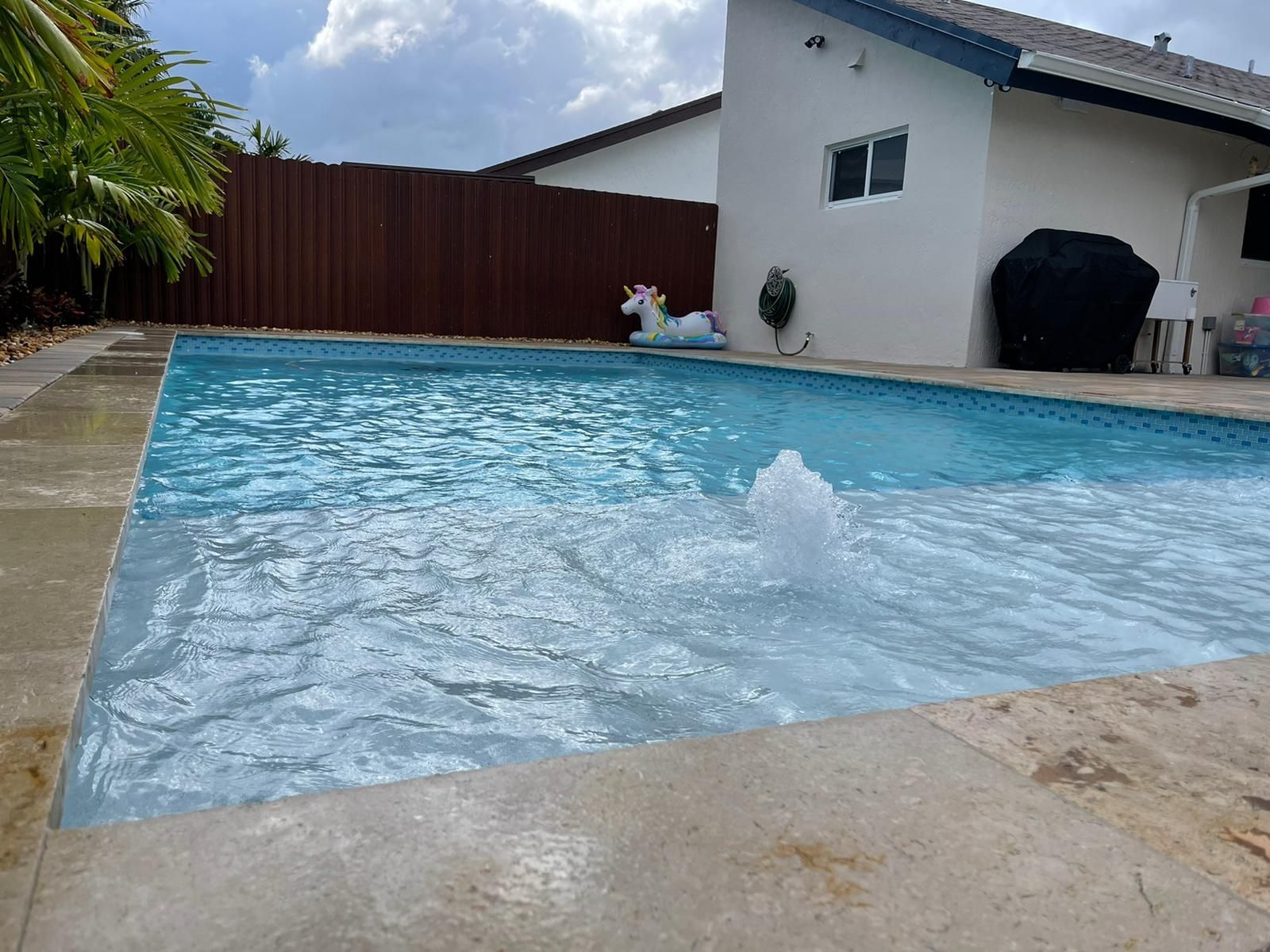 A swimming pool with a unicorn float in it