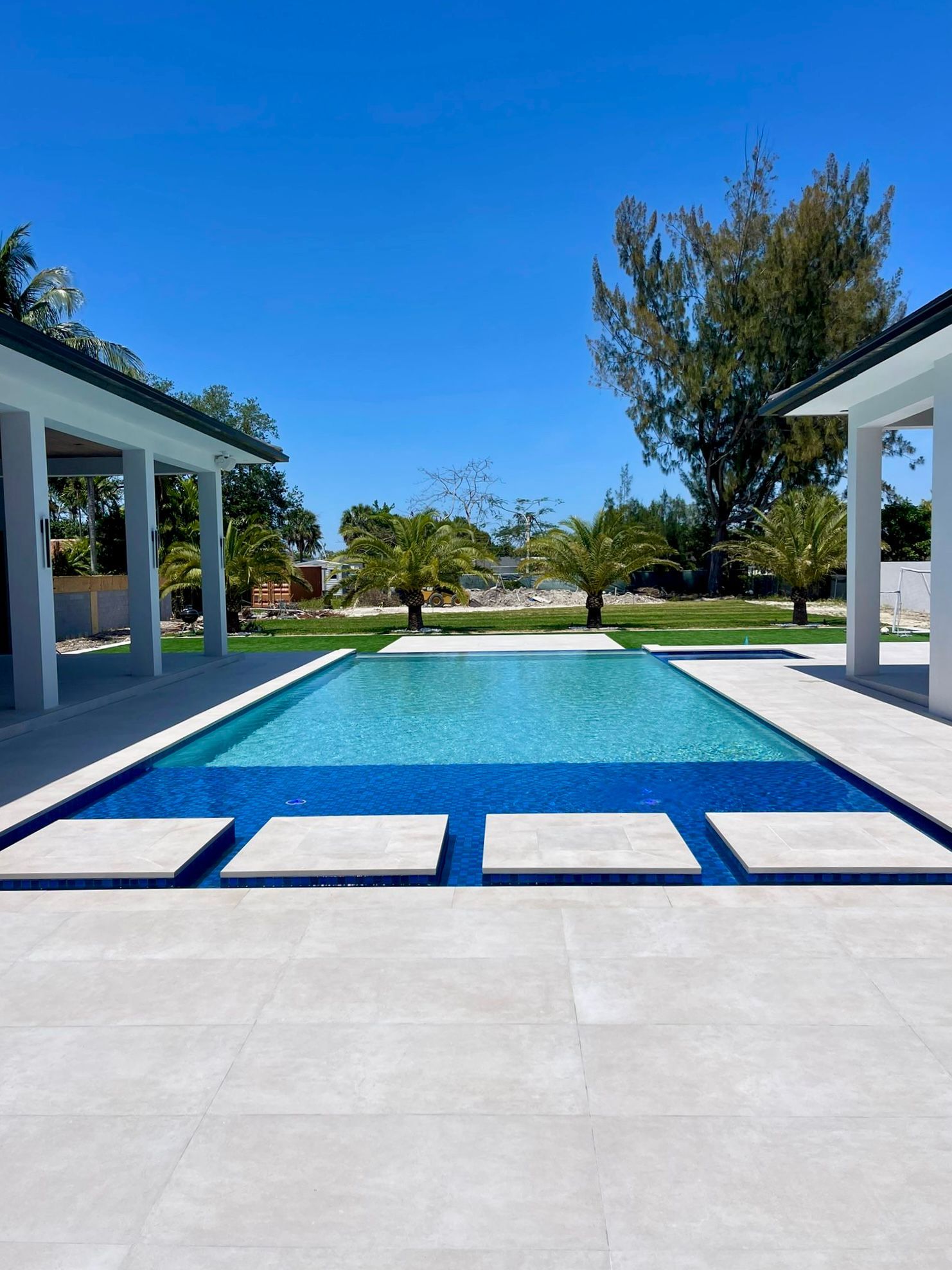 There is a large swimming pool in the middle of the yard.