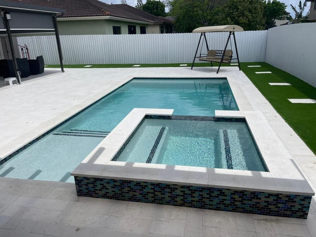 A large swimming pool with a swing in the backyard