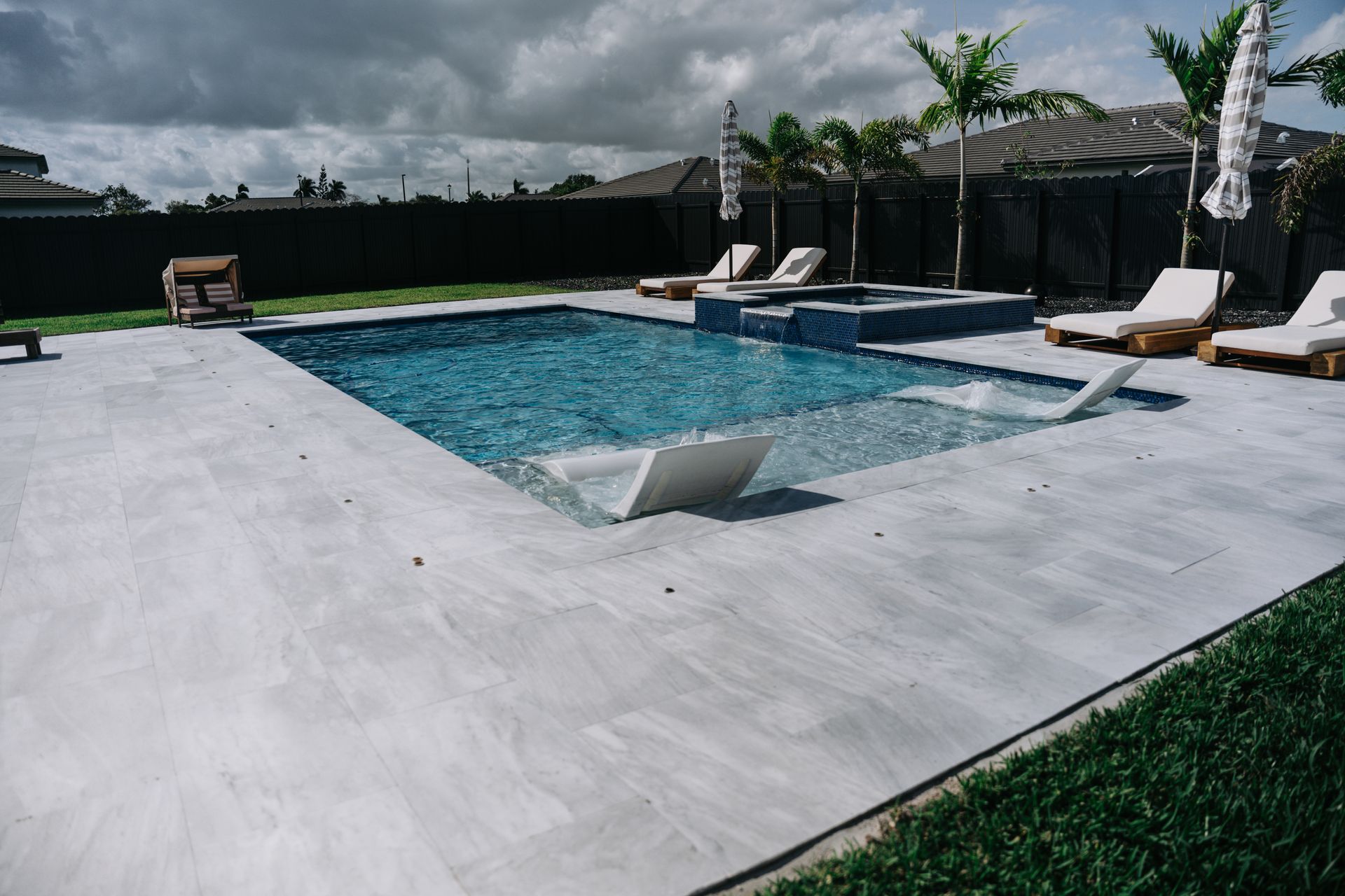 A large swimming pool surrounded by chairs and umbrellas