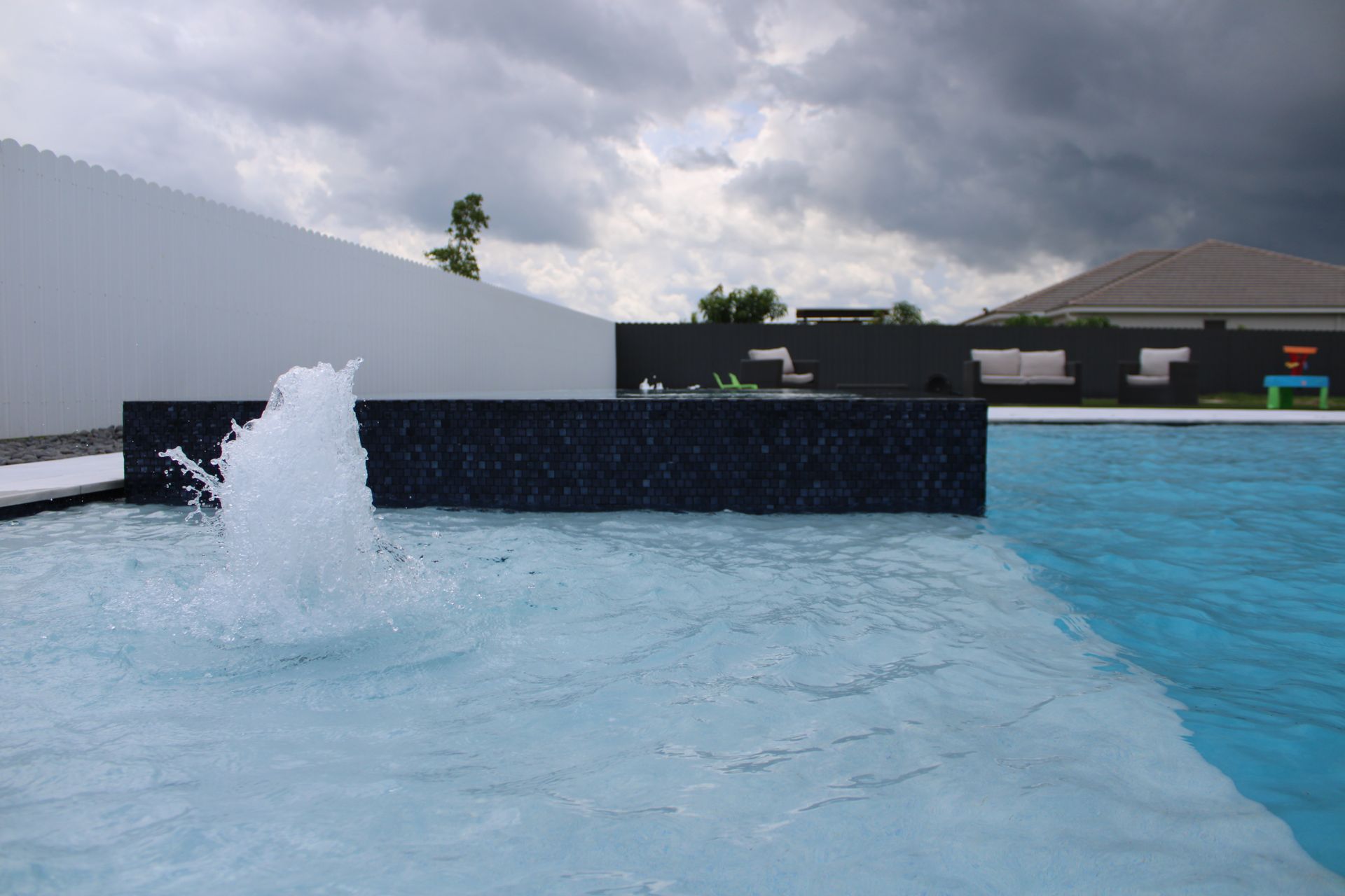 A swimming pool with a fountain in the middle of it.
