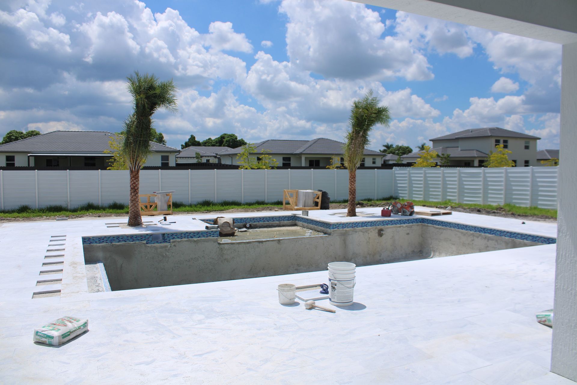 A swimming pool is being built in the backyard of a house.