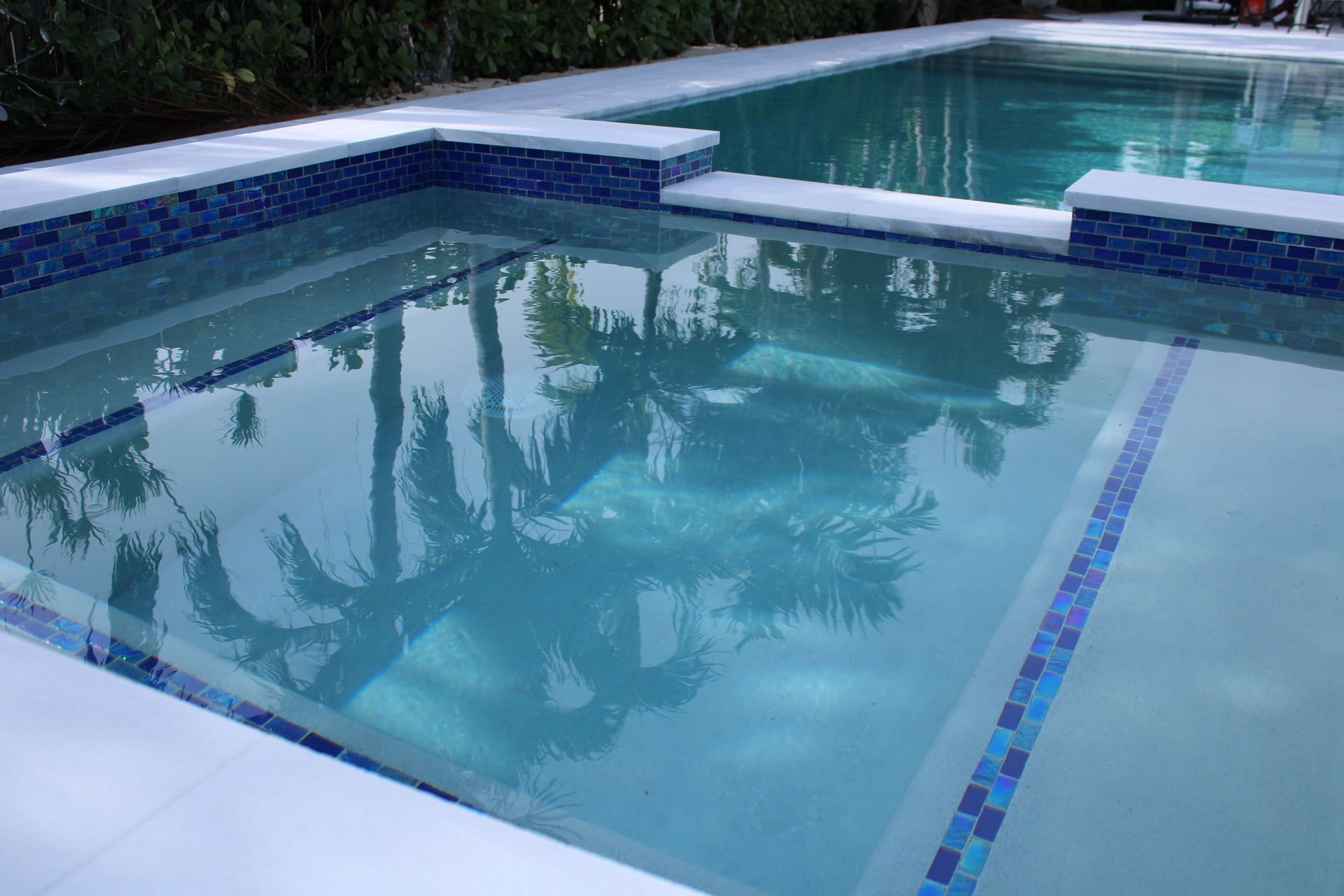 A large swimming pool with trees reflected in the water.