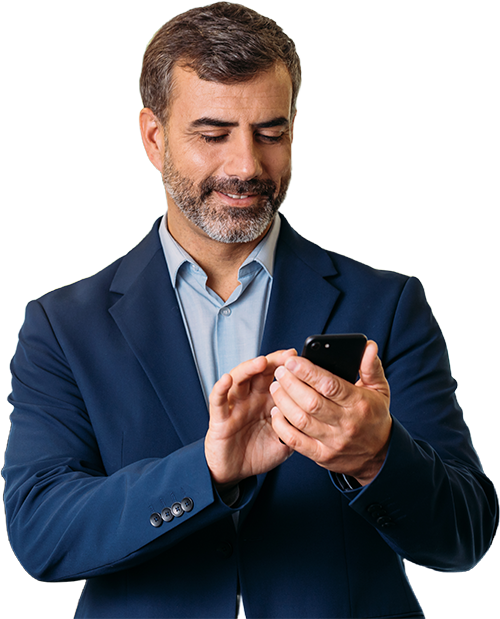 Man in blue suit, smiling, looking at and using a smartphone.