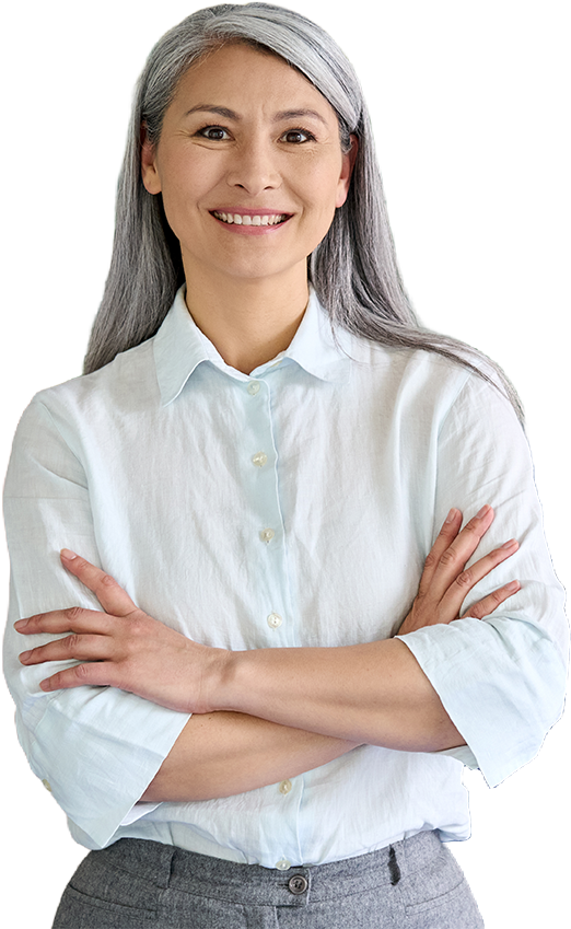 Woman with gray hair and crossed arms, smiling, wearing a light blue button-up shirt.