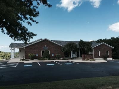 Brick building with handicap parking under a blue sky.