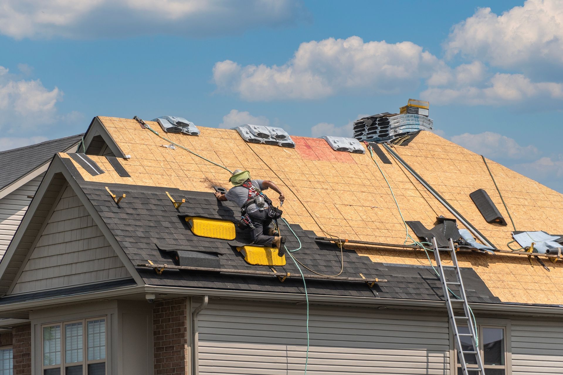 Two men are working on the roof of a house.
