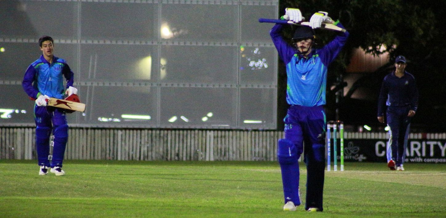 A man is hitting a cricket ball with a bat.