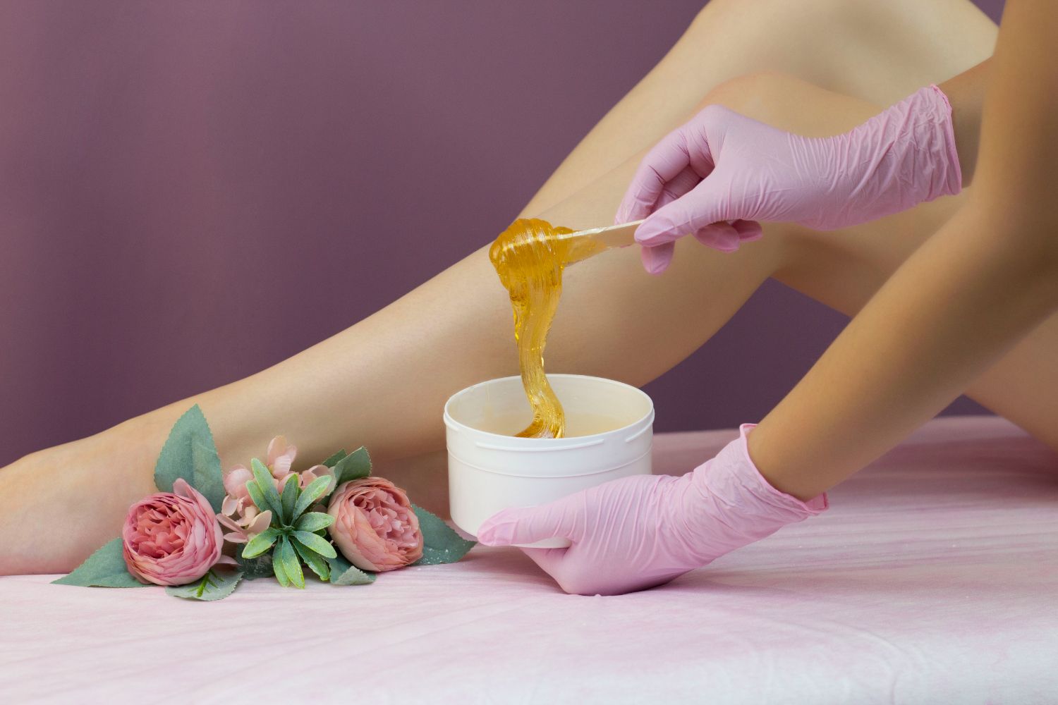 A woman is getting her legs waxed in a beauty salon.