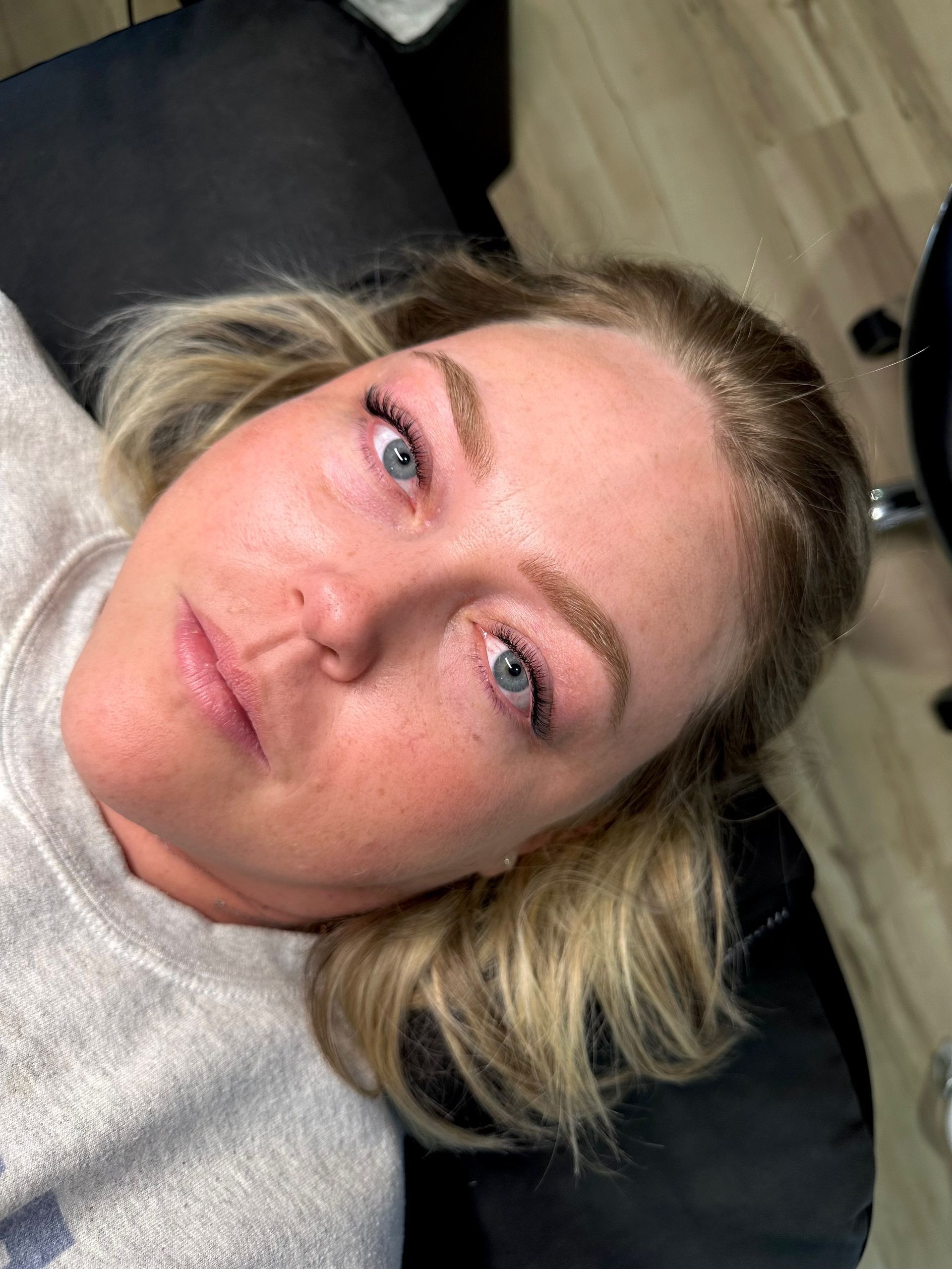 A woman is laying on a bed with her eyes closed.