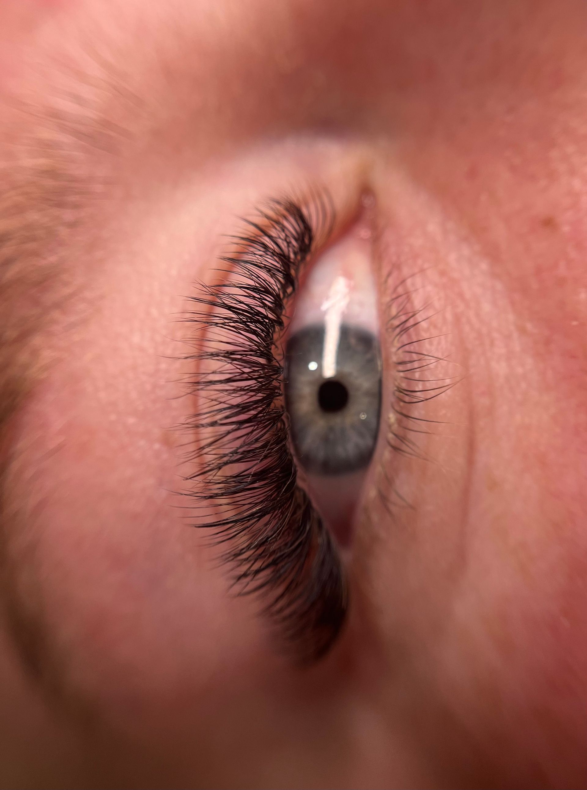 A close up of a woman 's eye with long eyelashes.