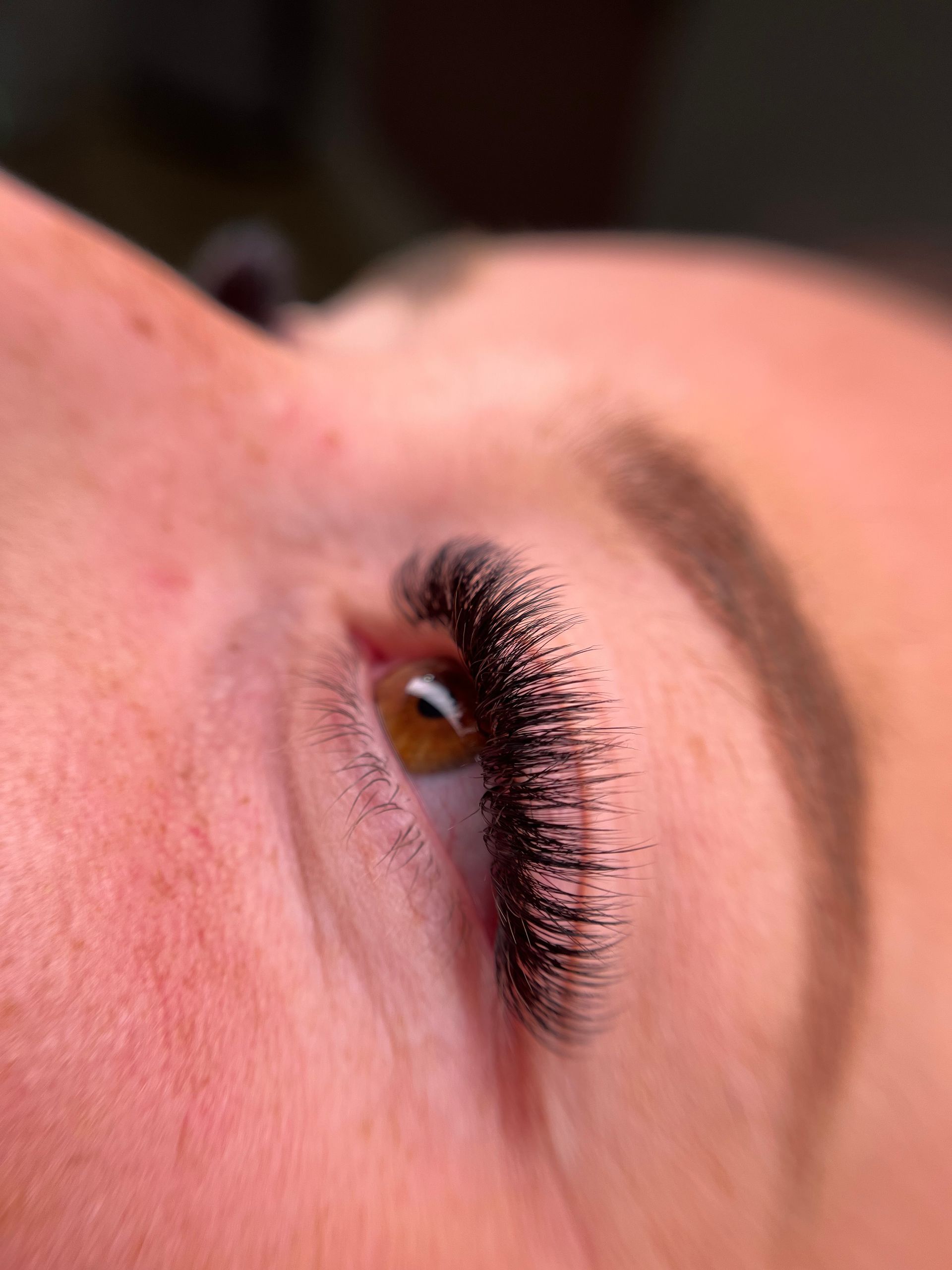 A close up of a woman 's eye with long eyelashes.